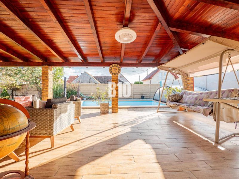 Eine geräumige Terrasse in einem Einfamilienhaus in Nitra mit einem Pool und einer Schaukel.