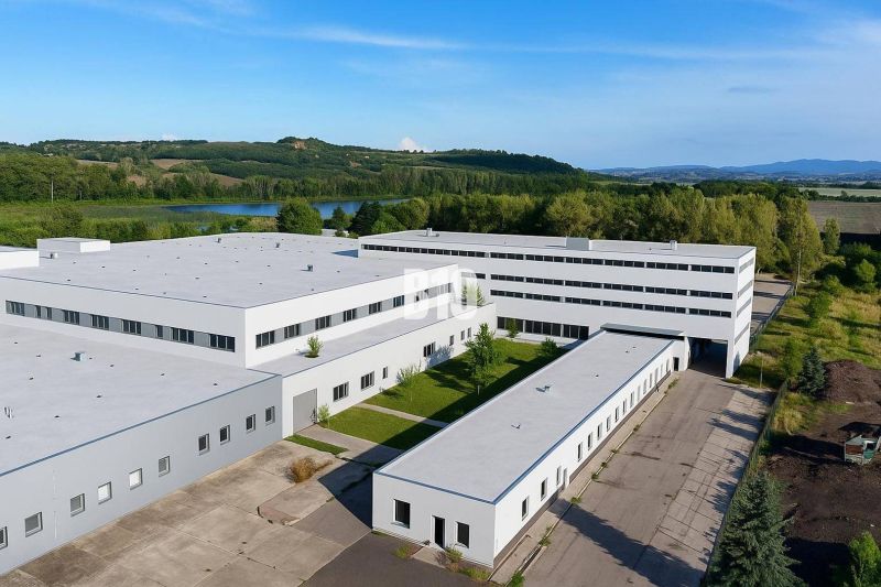 Produktionsräume in Levice mit einem angelegten Gelände, umgeben von Grünflächen und einem Teich.