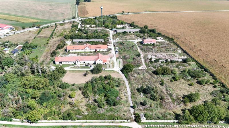Ein Gelände mit Gebäuden und Natur, umgeben von landwirtschaftlichen und forstwirtschaftlichen Flächen in Levice.
