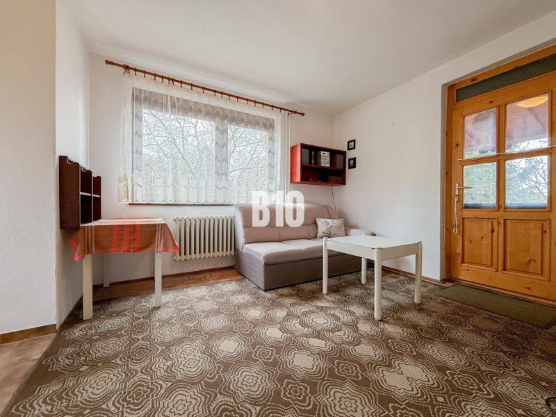Wohnzimmer in einem Einfamilienhaus mit Sofa, Tisch und Teppich.