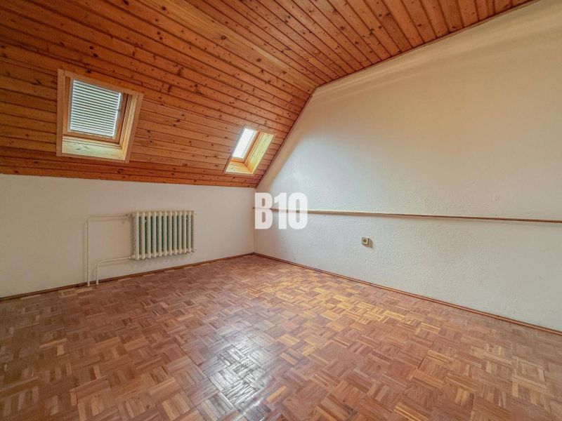 Ein Zimmer in einem Einfamilienhaus mit Holzverkleidung und einem Boden mit Holzdekor.