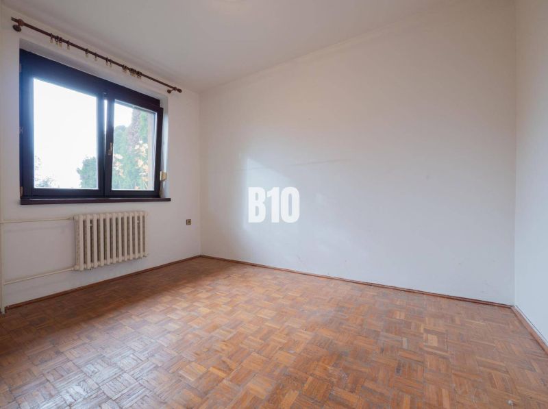 Ein leerer Raum mit Holzboden in einem Einfamilienhaus, großes Fenster.