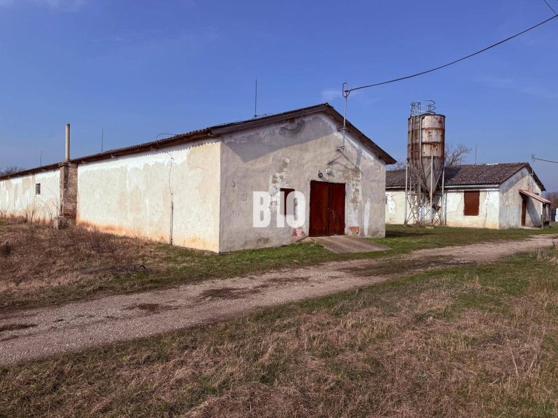 Produktionsräume in Turá mit landwirtschaftlicher Architektur und einem Silo im Hintergrund.