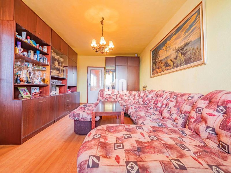 Wohnzimmer in einer 3-Zimmer-Wohnung mit Holzboden und Ecksofa.