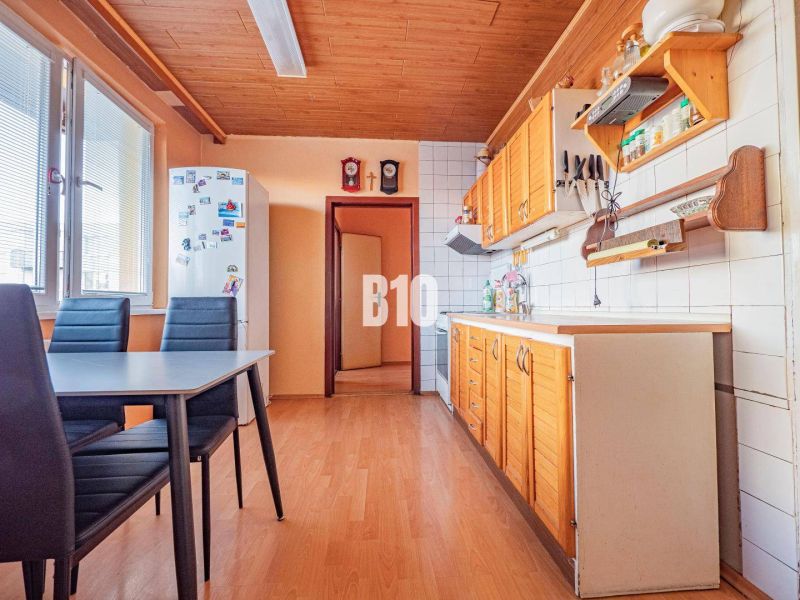 Küche in einer 3-Zimmer-Wohnung mit Holzboden und Esstisch.