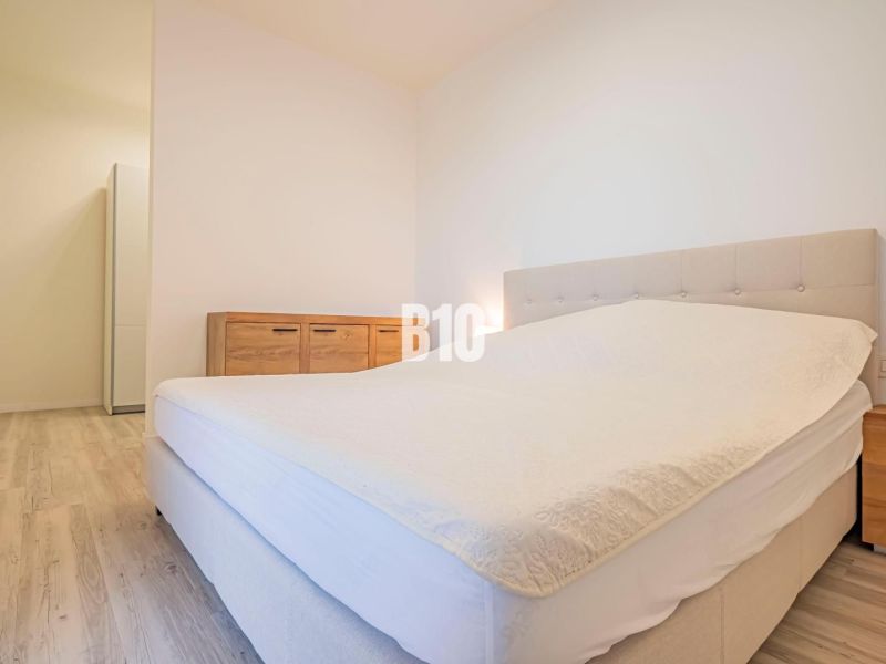 Schlafzimmer mit Bett, Möbeln und Boden in Holzdekor, 3-Zimmer-Wohnung.