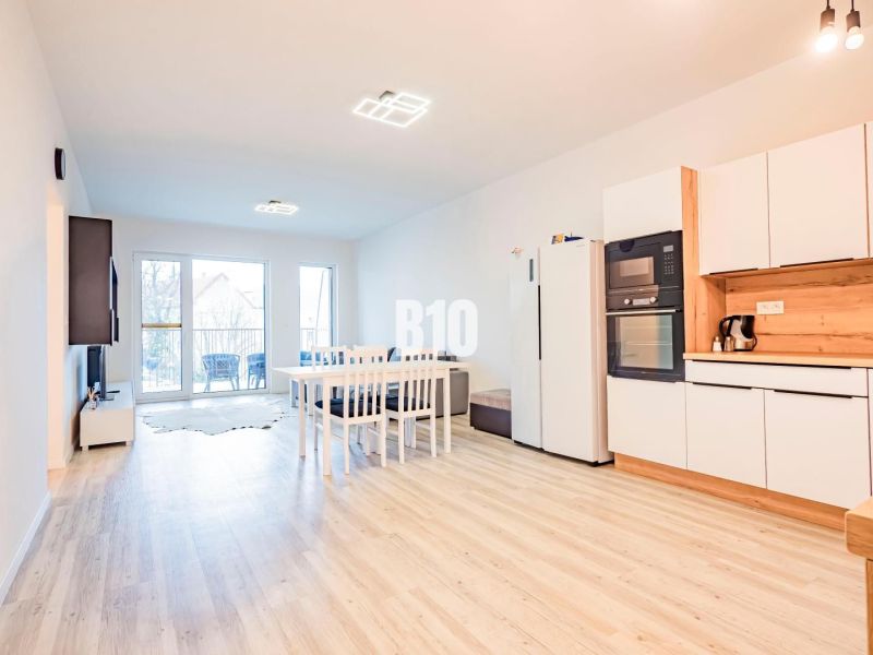 Küche in einer 3-Zimmer-Wohnung mit Holzboden und Esstisch.