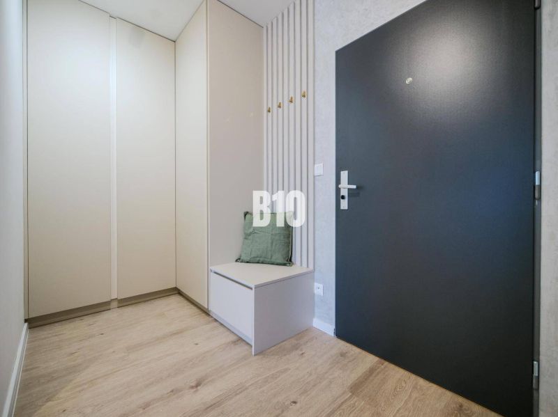 Eingangsflur einer 2-Zimmer-Wohnung mit Holzboden und stilvollem Stauraum.