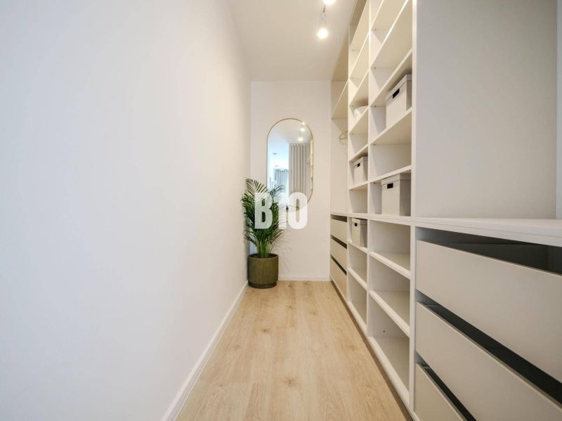 Flur mit Regalen und Spiegel, Boden mit Holzdekor in einer 2-Zimmer-Wohnung.