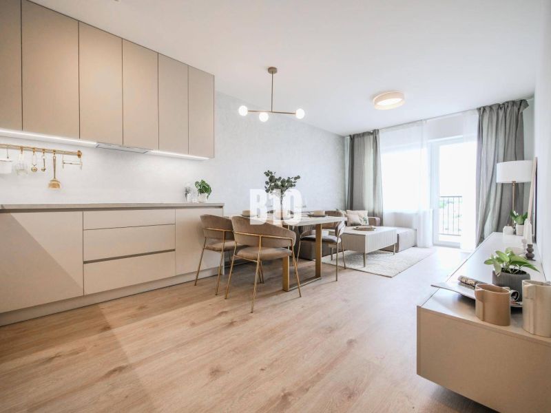 Wohnzimmer verbunden mit Küche in einer 2-Zimmer-Wohnung mit Holzboden.