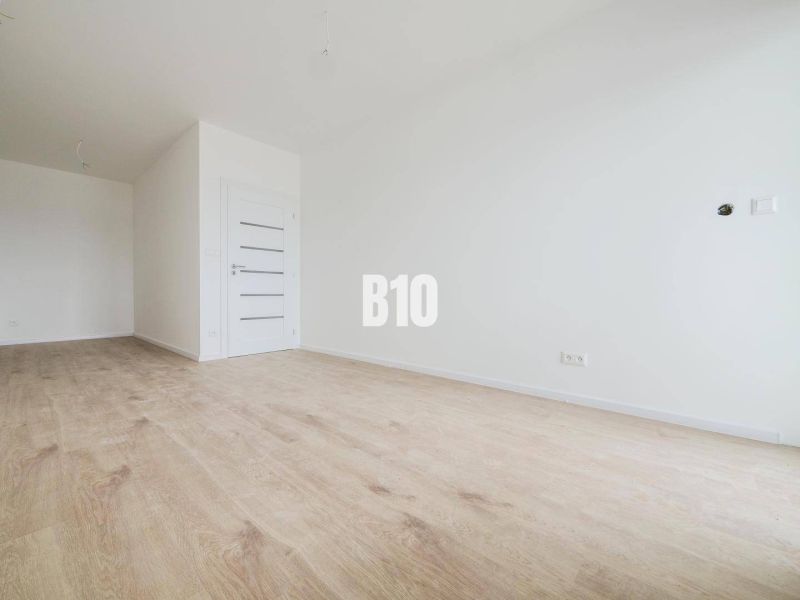 Geräumiges Interieur mit Holzboden und weißen Wänden in einer 2-Zimmer-Wohnung.
