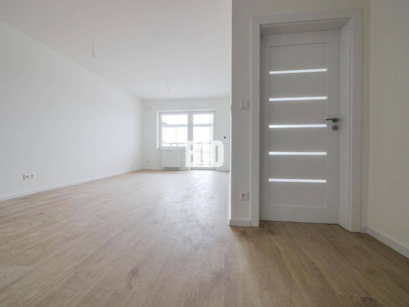 Geräumige helle 2-Zimmer-Wohnung mit Holzboden und weißen Türen.