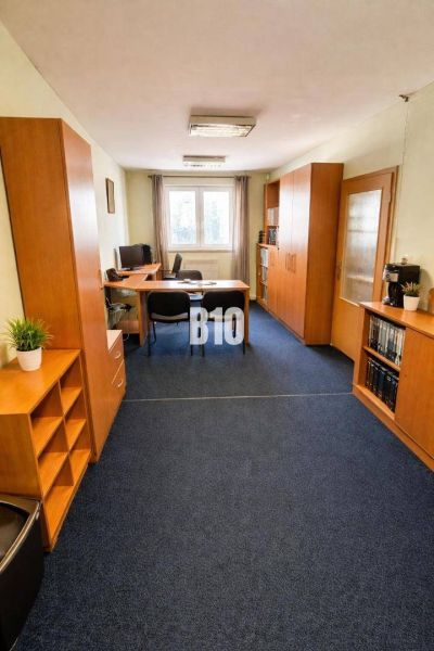 Büro mit blauem Teppichboden und Holzmöbeln im Gebäude.