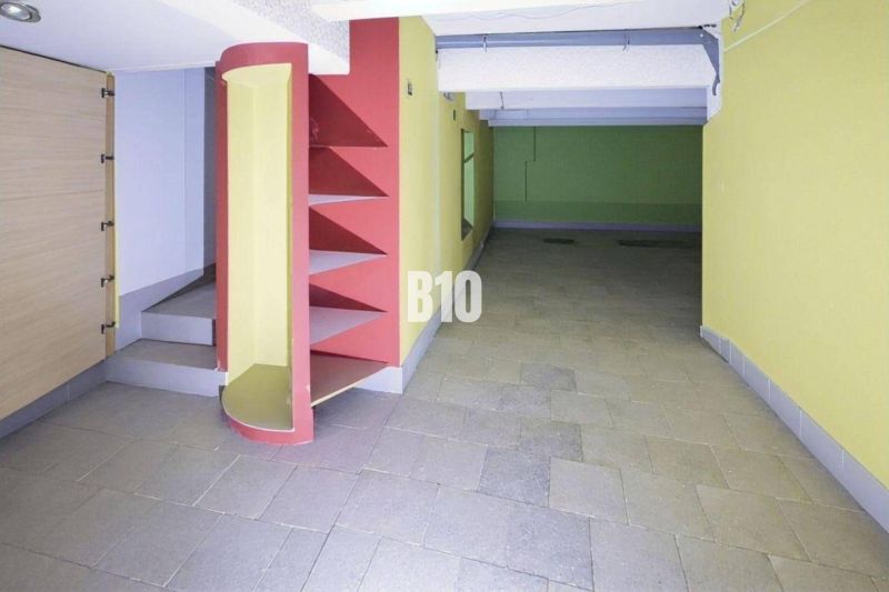 Innenraum von Geschäftsräumen mit bunten Wänden, Regalen und Treppen auf Fliesen.