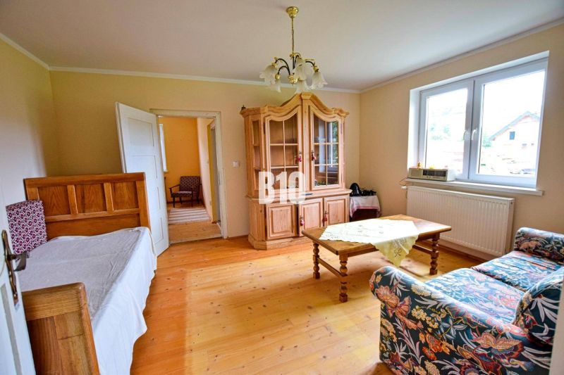 Wohnzimmer mit Sofa, Schrank und Holzboden in einem Einfamilienhaus.