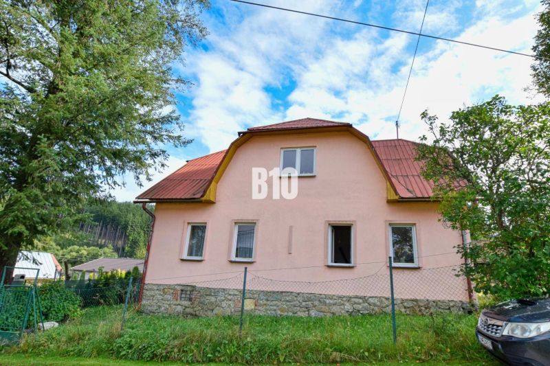 Ein Einfamilienhaus in Makov mit einem Steinfundament und einem roten Dach, umgeben von Grün.
