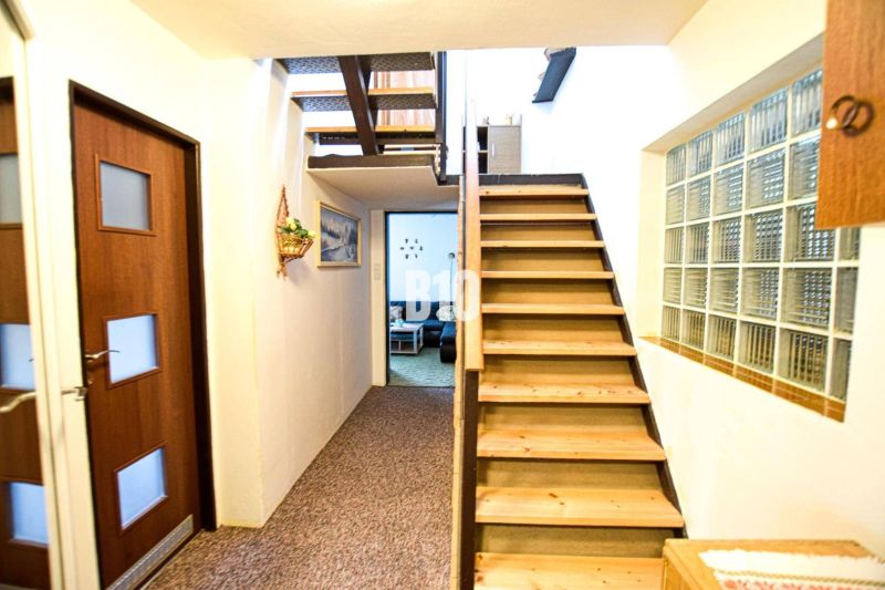 Das Innere der Hütte mit einer Holztreppe und einer verglasten Wand.