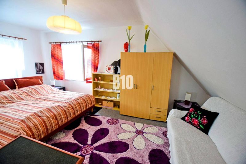 Gemütliches Schlafzimmer in einer Hütte mit einem bunten Teppich, einem Schrank und einem Doppelbett.