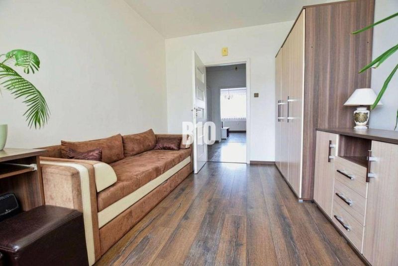 Sofa, Boden mit Holzdekor und Schrank in einer 3-Zimmer-Wohnung.