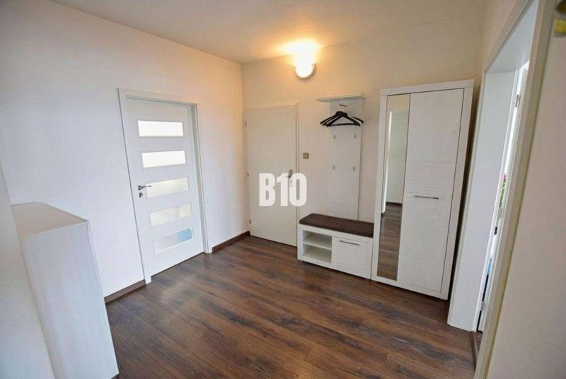 Eingangsbereich einer 3-Zimmer-Wohnung mit Holzboden, Kleiderschrank und Garderobe.