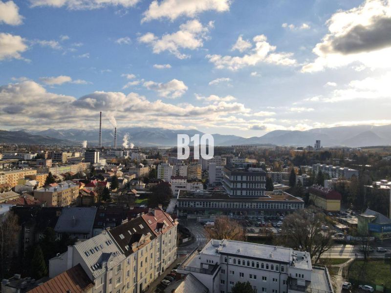 Die Stadt Žilina mit Panorama, Wohnhäuser und Industriegebiet im Vordergrund.