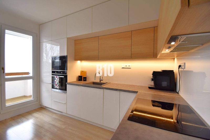 Küche einer 3-Zimmer-Wohnung mit Holzboden und eingebauten Geräten.