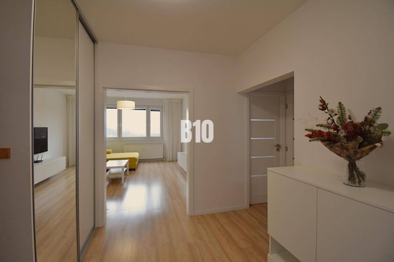 Innenraum einer 3-Zimmer-Wohnung mit Blumendekoration und Holzboden.
