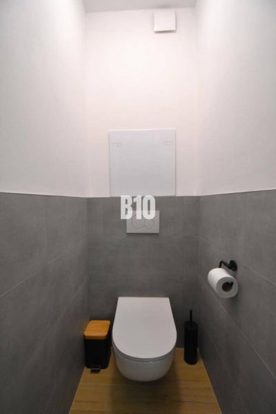 Toilette mit Fliesen, Boden mit Holzdekor in einer 3-Zimmer-Wohnung.
