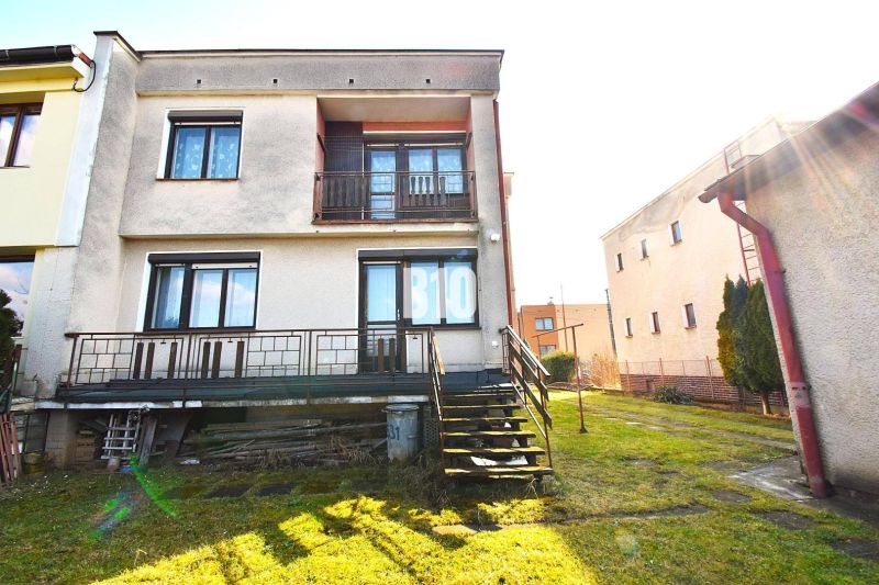 Ein Einfamilienhaus in Žilina mit Terrasse, Rasen und Treppen, die zum Garten führen.