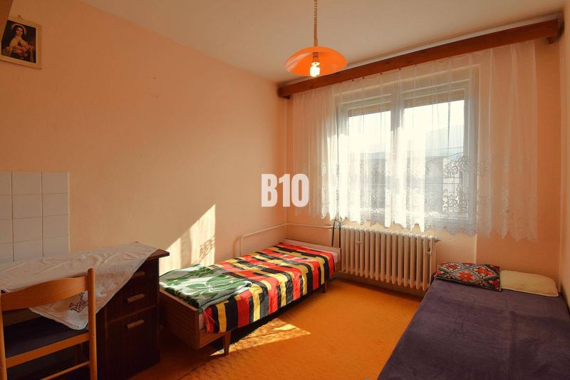 Ein Zimmer in einem Einfamilienhaus mit einfacher Einrichtung, einem Bett und einer orangefarbenen Laterne.