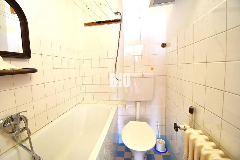 Badezimmer in einem Einfamilienhaus mit Badewanne, Toilette und gefliesten Wänden.