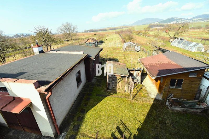 Ein Einfamilienhaus in Žilina mit Anbauten, Garten und Blick auf die umliegende Landschaft.