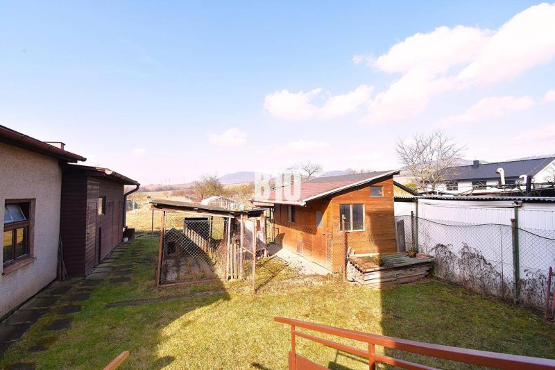 Ein Garten bei einem Einfamilienhaus in Žilina mit einem Holz-Anbau und Blick auf die Landschaft.