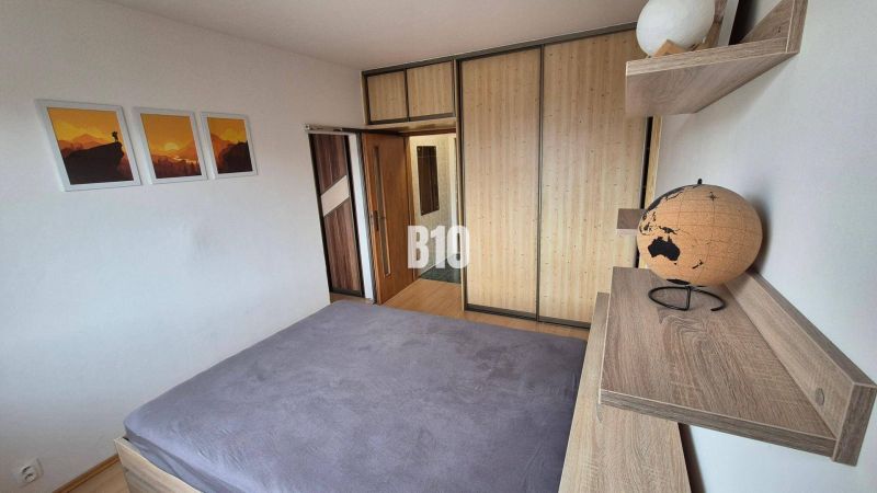 Schlafzimmer in einer Wohnung mit 5 oder mehr Zimmern mit Bett, Schrank und Dekorationen.