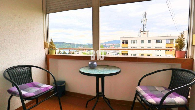 Balkon mit Blick auf Žilina aus einer 4-Zimmer-Wohnung, zwei Stühle, ein Tisch.