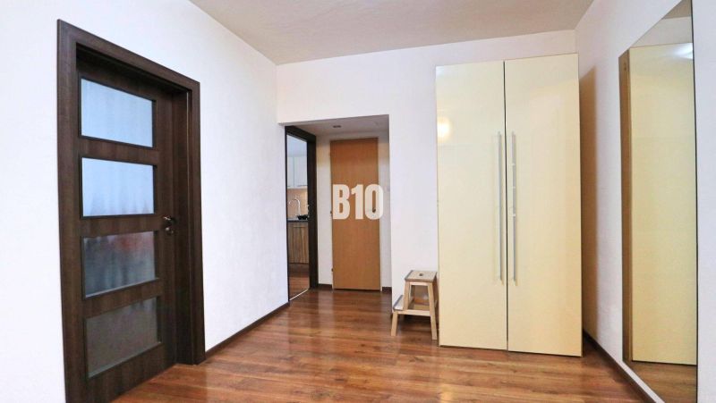 Innenraum einer 4-Zimmer-Wohnung mit Holzboden, Schrank und Spiegel.