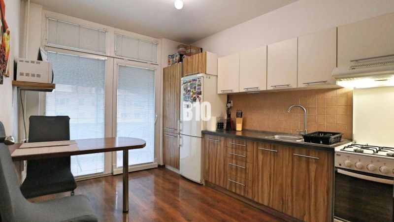 Küche in einer 4-Zimmer-Wohnung mit Holzboden und Essecke.