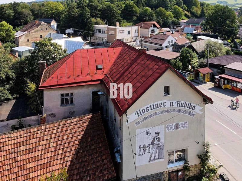 Gasthaus in Belej mit rotem Dach und Wandgemälde eines Mannes mit Bier.