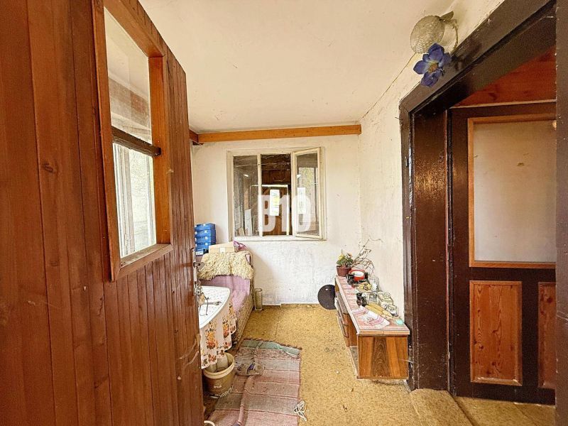 Innenraum eines Einfamilienhauses mit Holzverkleidung und einfacher Einrichtung.