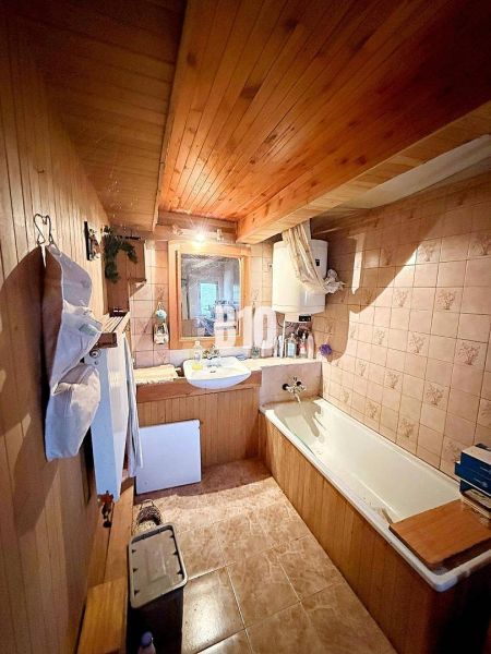 Ein Badezimmer in einem Einfamilienhaus mit Holzverkleidung und einer Badewanne.