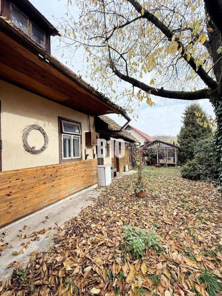 Das Äußere eines Einfamilienhauses in Kotešová mit Herbstblättern im Hof.