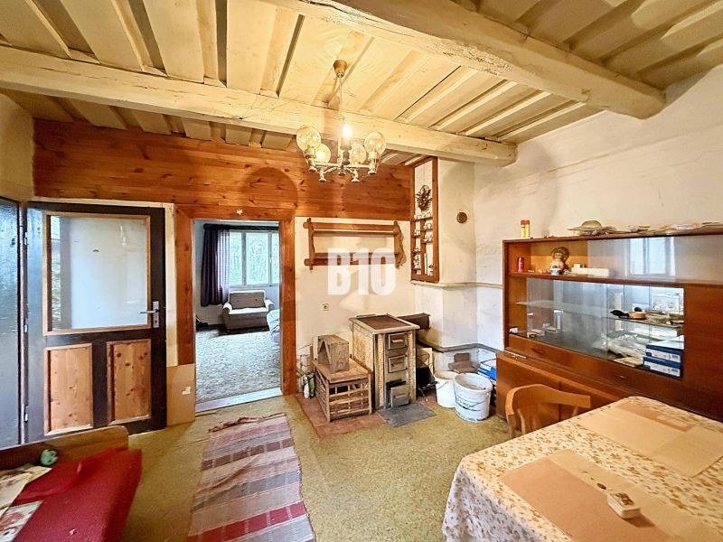 Innenraum eines Einfamilienhauses mit traditioneller Einrichtung, Kachelöfen, Teppichen und Holzdekor.