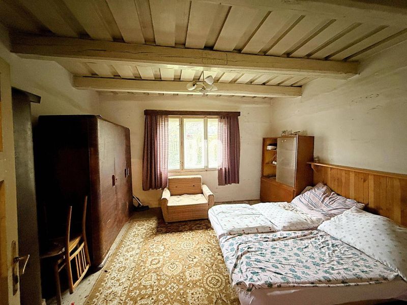 Schlafzimmer in einem Einfamilienhaus mit Holzdecke, Bett und Möbeln.