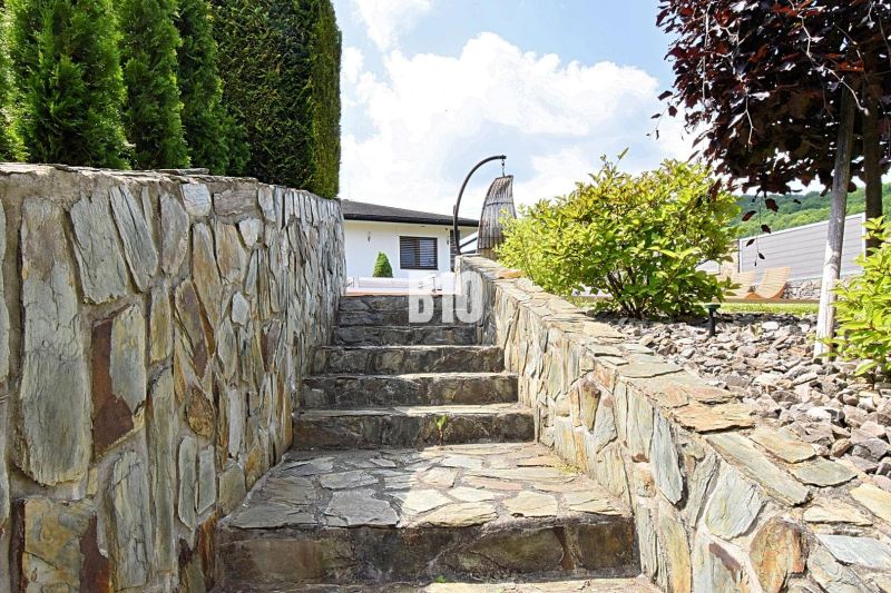 Steintreppen, die zum Garten bei der Villa in Súľov-Hradná führen, umgeben von Grün.