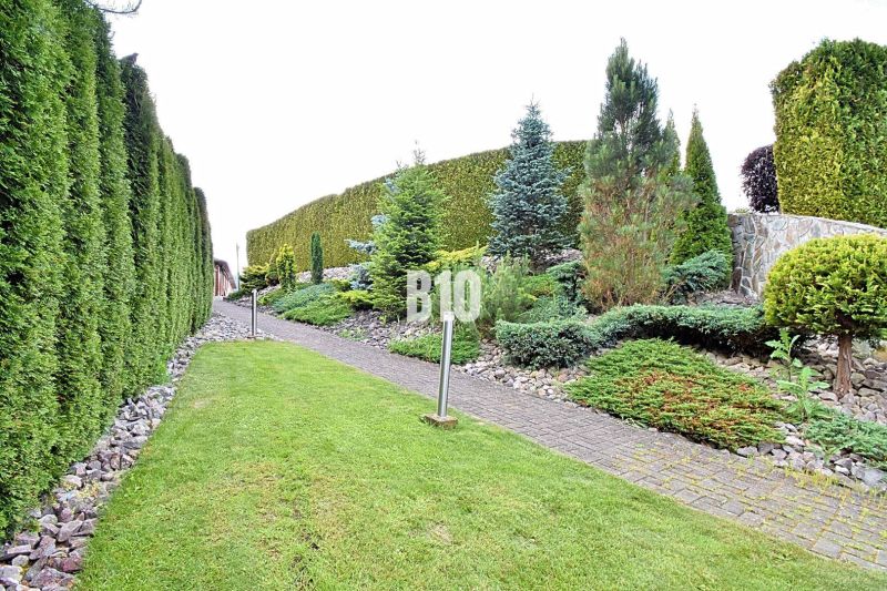 Der Garten bei der Villa in Súľov-Hradná mit gepflegter Hecke und Gehweg.