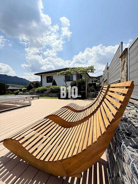 Holzliegestühle auf der Terrasse bei der Villa in Súľov-Hradná, mit Blick auf den Garten.