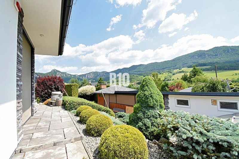Ein schöner Garten bei einer Villa in Súľov-Hradná mit Blick auf die Berge und gepflegter Vegetation.