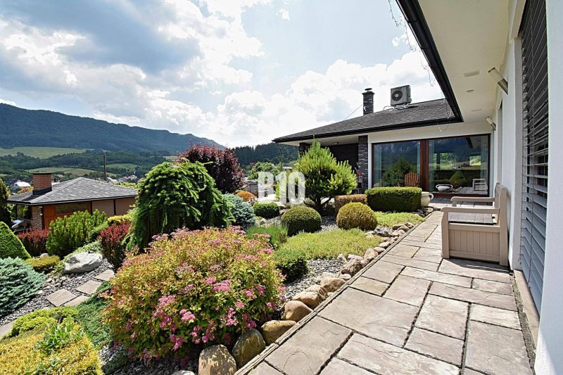 Der Garten bei der Villa in Súľov-Hradná mit gepflegten Pflanzen und Blick auf die Berge.