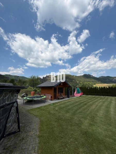 Ein Garten mit einem Häuschen und einem Trampolin in einer Villa in Súľov-Hradná.