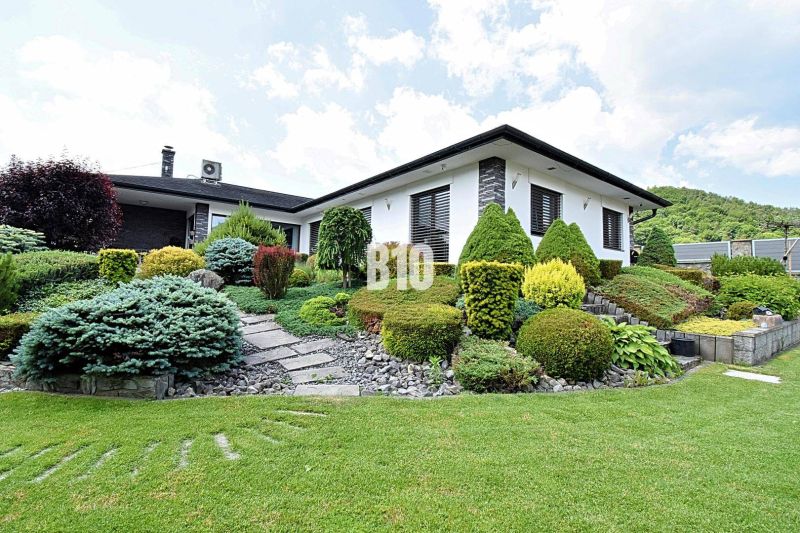 Eine Villa in Súľov-Hradná mit einem wunderschönen Garten und gepflegten Sträuchern.